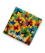 Un portavaso de 9,5 x 9,5 cm, elaborado en MDF, resina y fomi negro. Cuenta con ilustraciones inspiradas en las mariposas colombianas